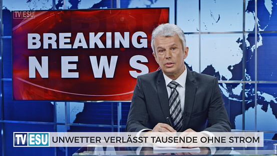 Male anchor presenting breaking news about extreme weather causing power outage in German language.