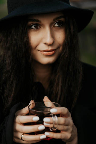 istock Woman Dressed in Black . Woman Drinking Coffee in Cold 1289019992