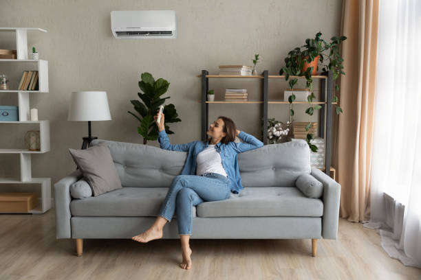 istock Young woman relax on couch turn on AC 1289021343