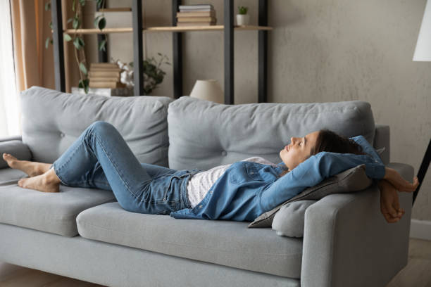 istock Exhausted woman relax on sofa at home daydreaming 1289021371