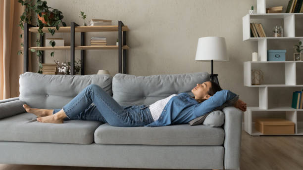 istock Banner view of woman lying on couch sleeping 1289021373