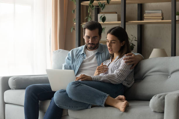 istock Young couple relax at home using modern laptop 1289021406