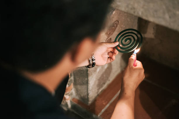 homme chinois asiatique allégé vers le haut de bobine de moustique à la cuisine - produits anti moustique photos et images de collection