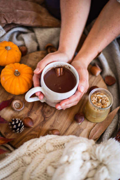 istock Woman holding mug of hot chocolate with both hands 1289024236