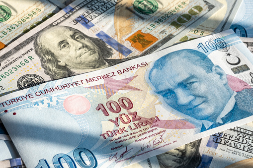 A heap of 100 Turkish Lira bill and 100 American Dollar bill. Image can be used all issues about forex and comparison of Turkish and American financial situations.
