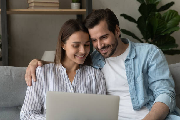 istock Happy couple relax at home using laptop 1289027508