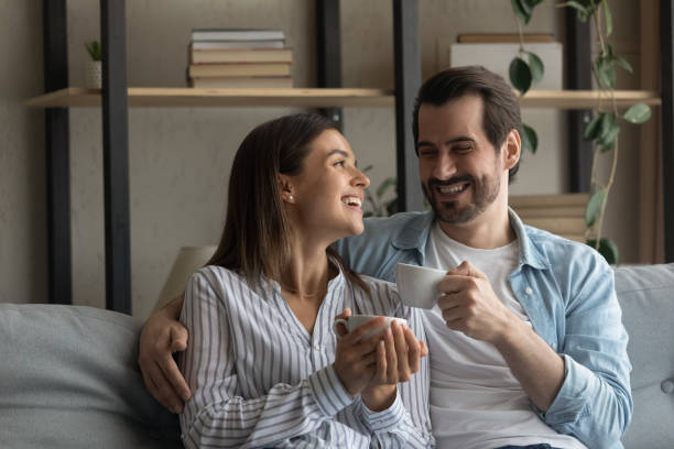 istock Happy couple relax on sofa drinking tea 1289027509
