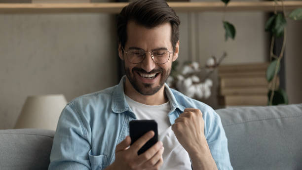 istock Banner view of excited man triumph with cellphone win 1289027514