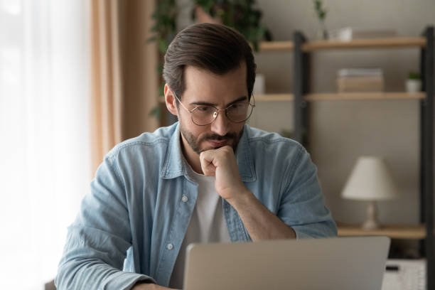 istock Pensive Caucasian man look at laptop screen thinking 1289027521