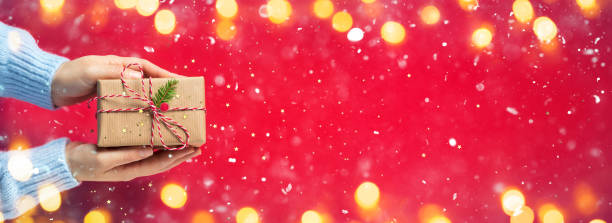 Woman Hands Giving Rustic Present With Snowing And Bokeh