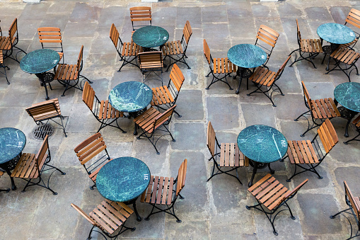High angle color image depicting lots of empty chairs and tables at a restaurant terrace in London, UK. No one is eating or drinking here because of the lockdown measures during the covid-19 pandemic.