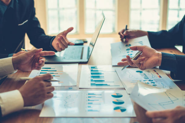 istock Group of business people meeting, discussing, analyzing graphs, financial data, and planning a marketing project together. 1289029824