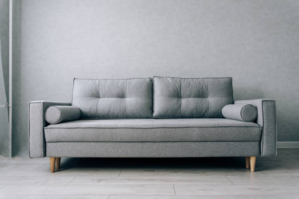 istock Modern grey sofa with wooden legs in the room 1289030057