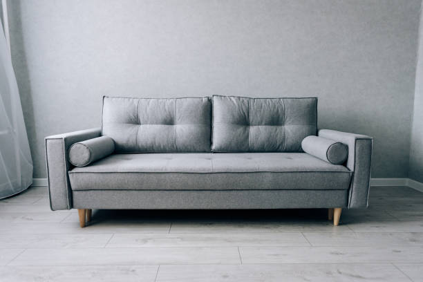 istock Modern grey sofa with wooden legs in the room 1289030090