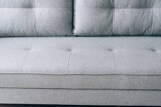 istock Modern grey sofa with wooden legs in the room 1289030093