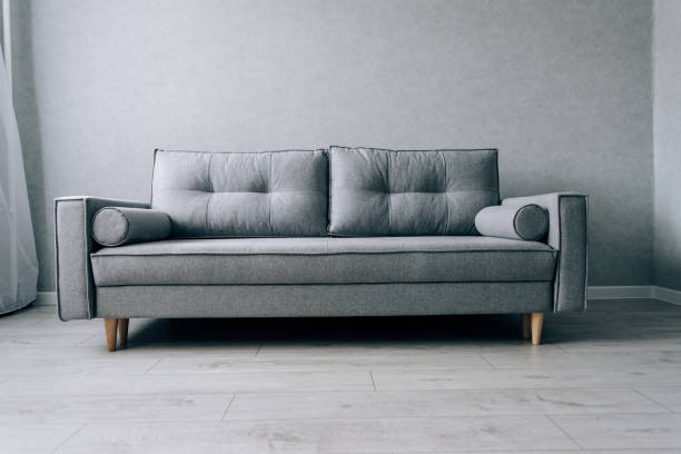 istock Modern grey sofa with wooden legs in the room 1289030119