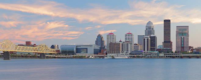 Panoramic view of the skyline of Louisville - the largest city in the commonwealth of Kentucky - as seen at dusk from across the Ohio river.