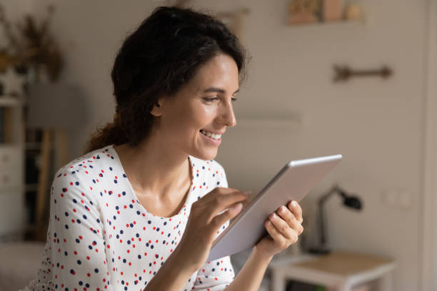 istock Smiling woman watch webinar on tablet gadget 1289033402