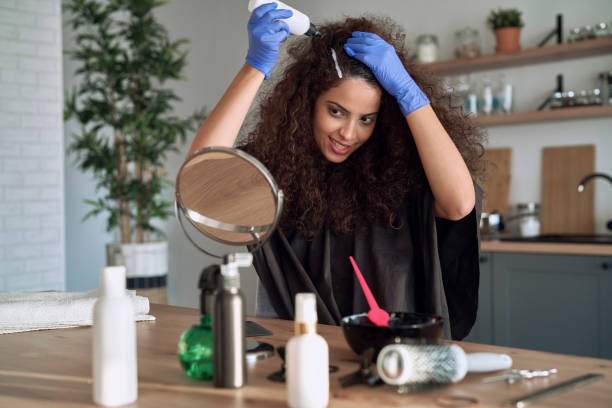 femme teant son cheveu à la maison - colorant capillaire photos et images de collection