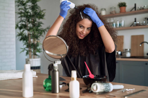 Woman dyeing her hair at home Woman dyeing her hair at home hair colour stock pictures, royalty-free photos & images