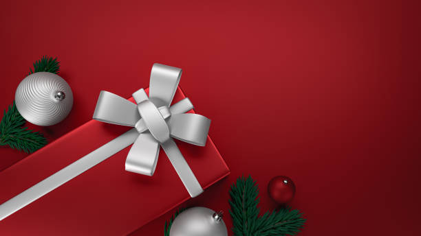 Christmas elegant gift box with a silver ribbon, red flat background. stock photo
