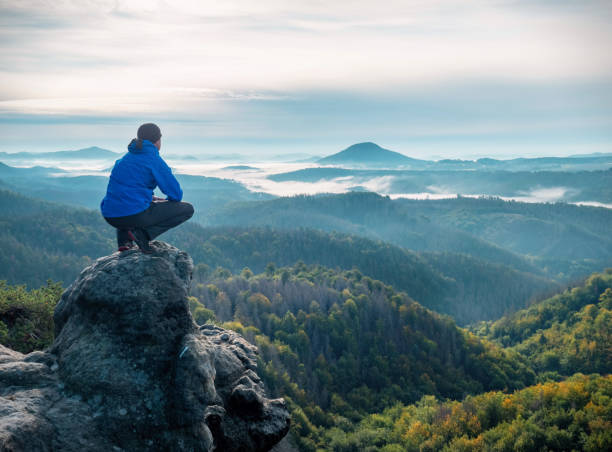 istock Hiker sit on cliff and looking beautiful landscape. 1289034841