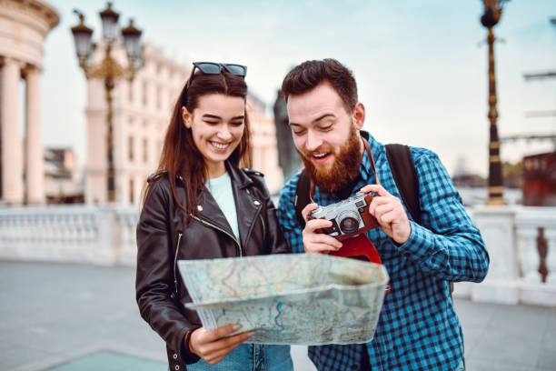 istock Cute Tourist Couple Exploring Locations On Map And Photographing 1289034984