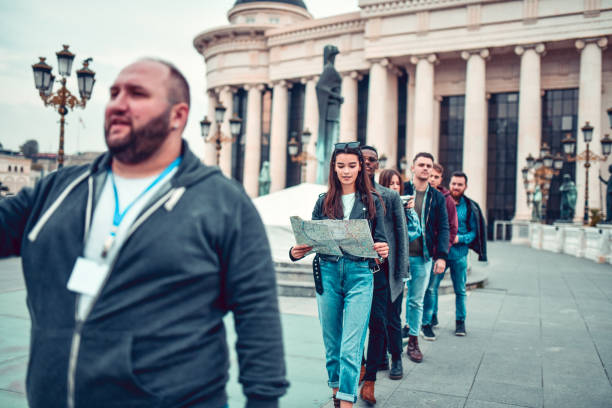 Tour Guide Leading His Group Through City Center