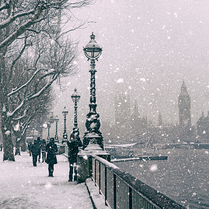 Black and white Jubilee Gardens and Houses of Parliament during a snowstorm in London.