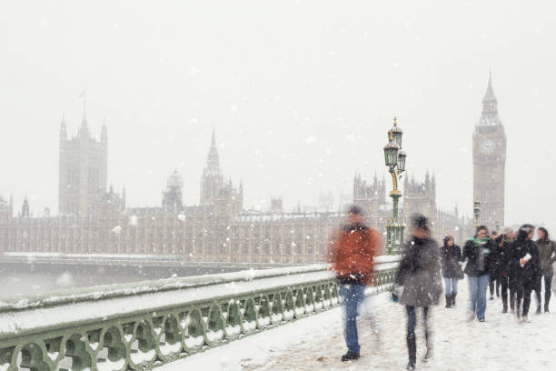 persone che camminano sul westminster bridge durante una tempesta di neve a londra - london england christmas snow winter foto e immagini stock