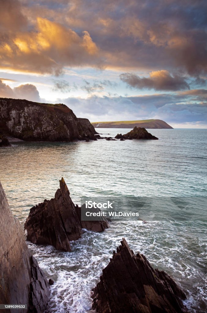 Welsh coastal sunset Sunset over rocky coastline in Pembrokeshire, Wales Pembrokeshire Coast National Park Stock Photo