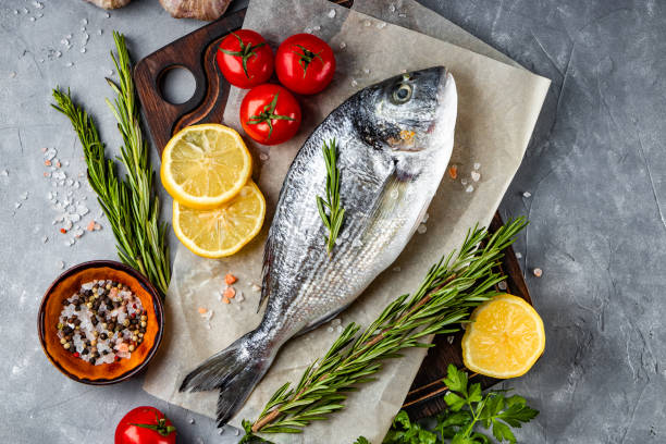 istock Raw dorado fish and spices for cooking it on gray background, top view 1289040432