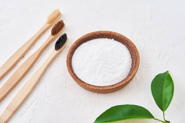 istock Three wooden bamboo toothbrushes and baking soda on white background, top view. Eco friendly toothbrushes, zero waste concept 1289040993