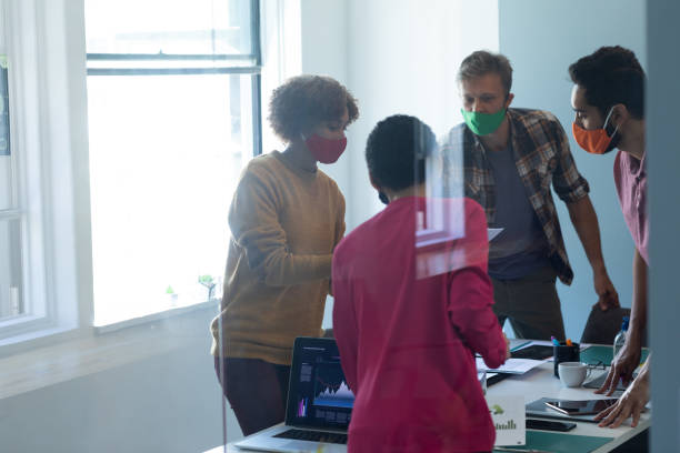 istock Diverse group of work colleagues wearing masks in an office 1289041930