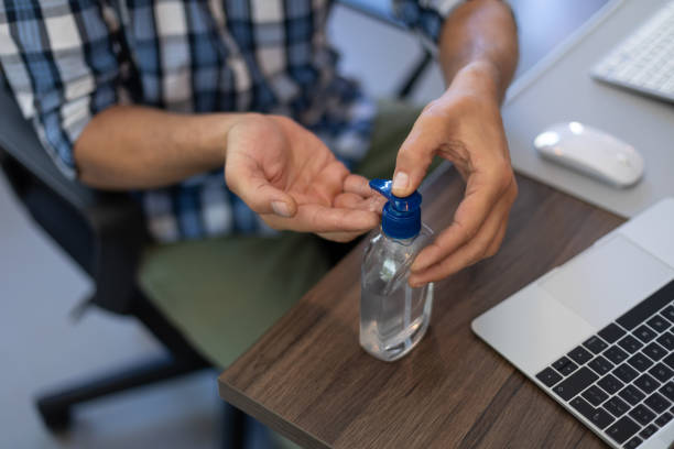 istock Caucasian man disinfecting his hands in an office 1289042170