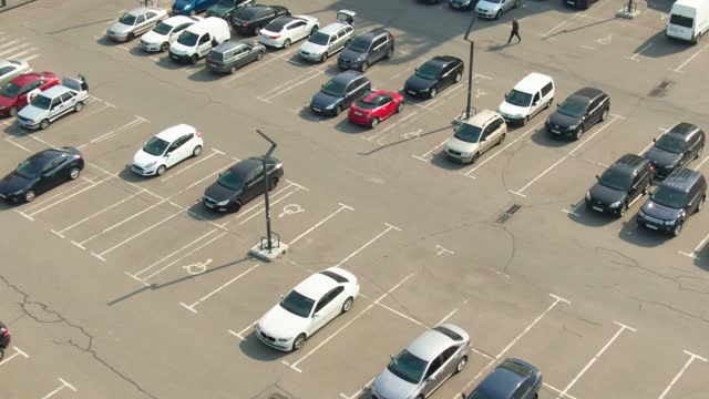 Aerial top view of the shopping mall parking lot with cars and empty spots