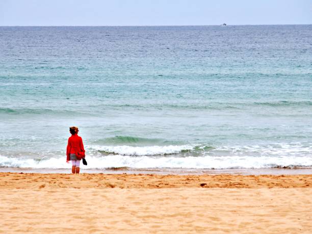 istock Rear View Of Man Standing On Beach Against Sky 1289042331
