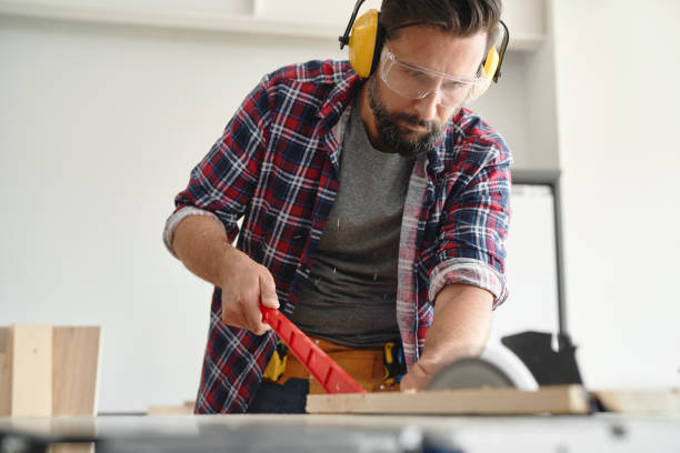 istock Carpenter cutting wood on a circular saw 1289042364