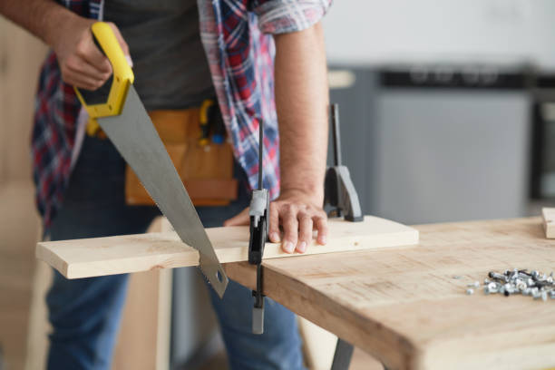 istock Carpenter cutting block of wood using hand saw 1289042591