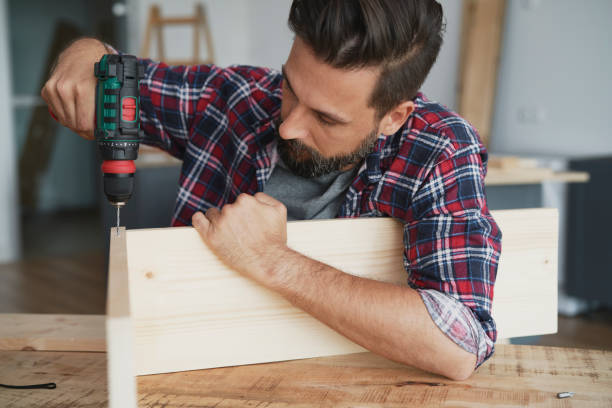 istock Carpenter drilling a hole in a wooden plank 1289043997