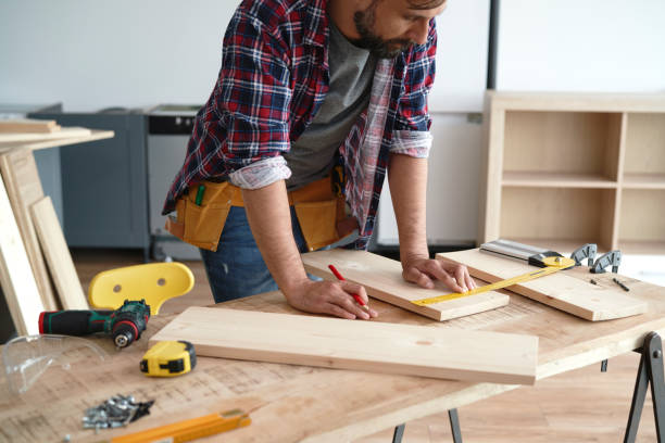 istock Carpenter measures the boards at the table 1289044084