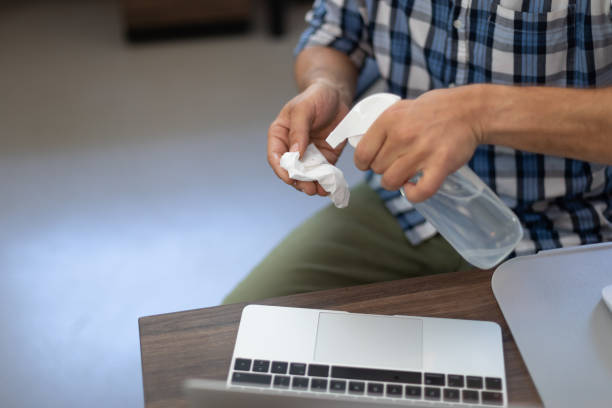 istock Caucasian man disinfecting his laptop in an office 1289044263