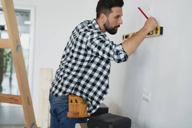 istock Focused carpenter using spirit level on the white wall 1289045084
