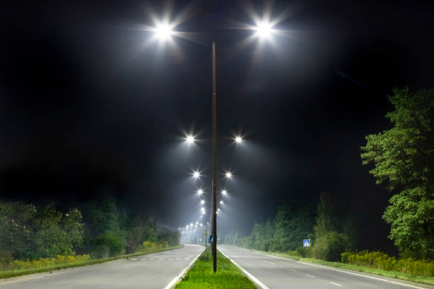 istock night empty road with bright LED streetlights, modern illumination 1289046040