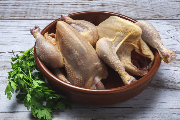 istock Whole coquelet chickens with raw vegetables ready to cook 1289047234