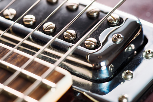 Close-up showing a humbucker pickup near the neck on an electric guitar.