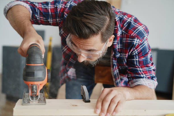 istock Front view of carpenter cutting boards with a jigsaw 1289049325