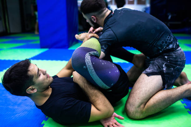 бразильские бойцы джиу-джитсу практикуют технику в боевом тренажерном зале - mixed martial arts combative sport jiu jitsu wrestling стоковые фото и изображения