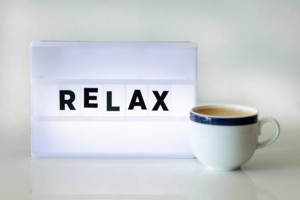 RELAX concepts with text on light box AND CUP OF COFFEE on desk table in home office.positive emotion to success