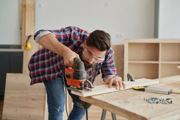 istock Carpenter sawing wood with an electric jigsaw 1289049995